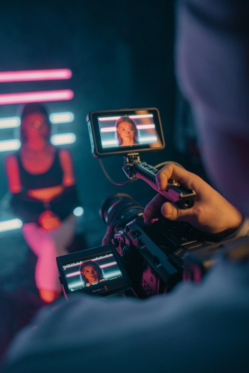Person holding black smartphone taking photo of man in black shirt